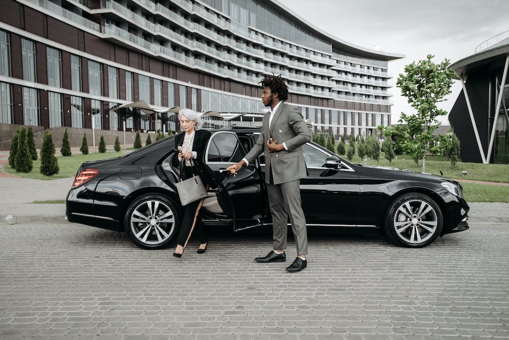 Professional chauffeur opening luxury car door for client in Australia